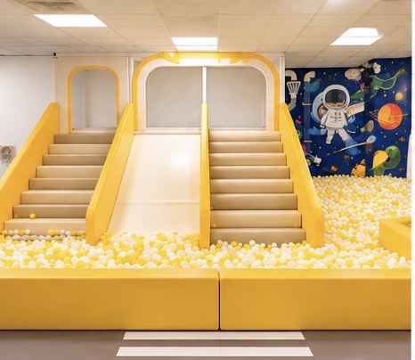 Sunshine-yellow slide and ball pit inside Kids Town